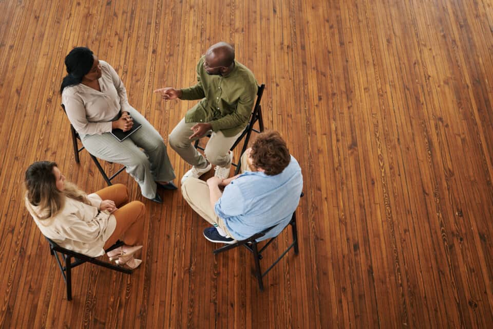 Therapist talking to patients in a group therapy setting